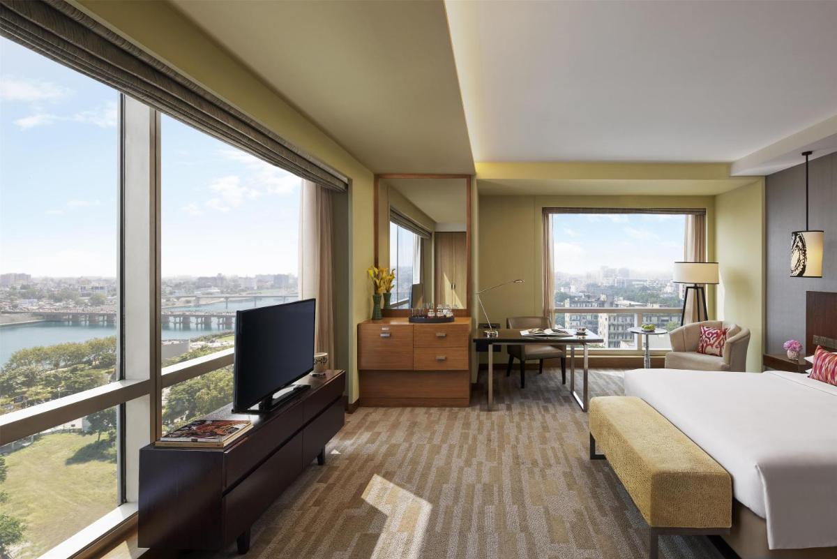 a hotel room with a bed and a large window at Hyatt Regency Ahmedabad in Ahmedabad