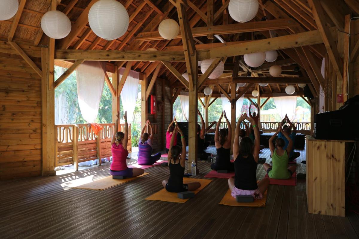- un groupe d'enfants assis dans un cours de yoga dans l'établissement Camping La Pinède, à Calvi
