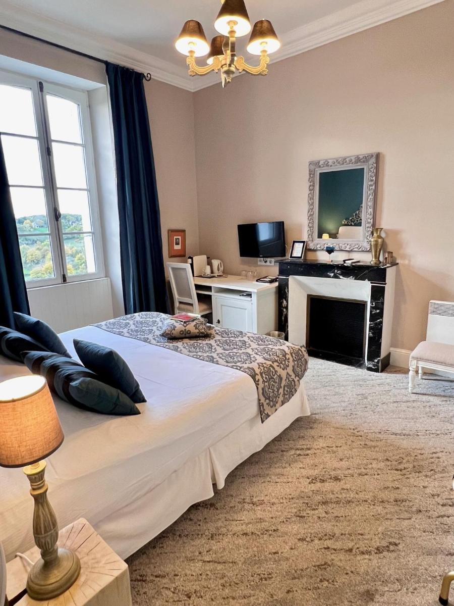 une chambre avec un grand lit et une cheminée dans l'établissement Château Hôtel Edward 1er, à Monpazier