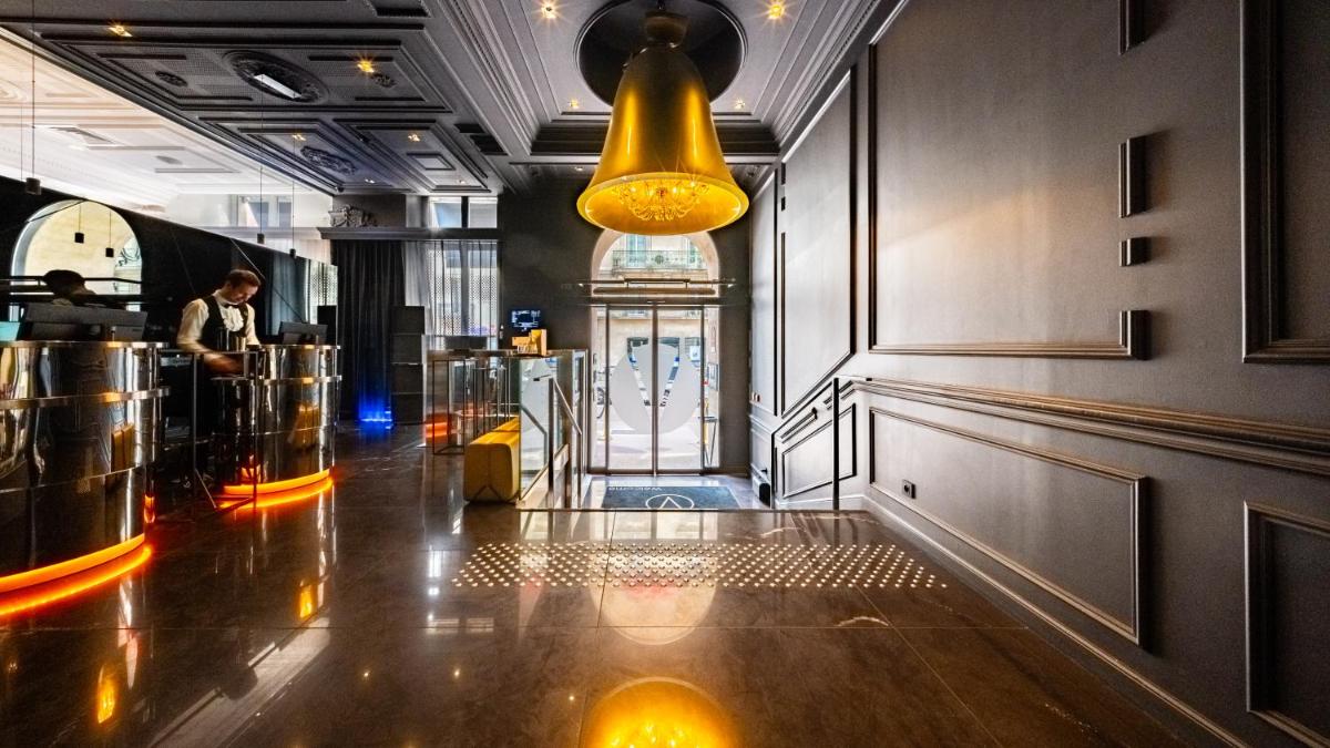 un bar avec une lumière jaune suspendue au plafond dans l'établissement Vertigo Hotel, By Marriott, a Member of Design Hotels, à Dijon 59 autres photos