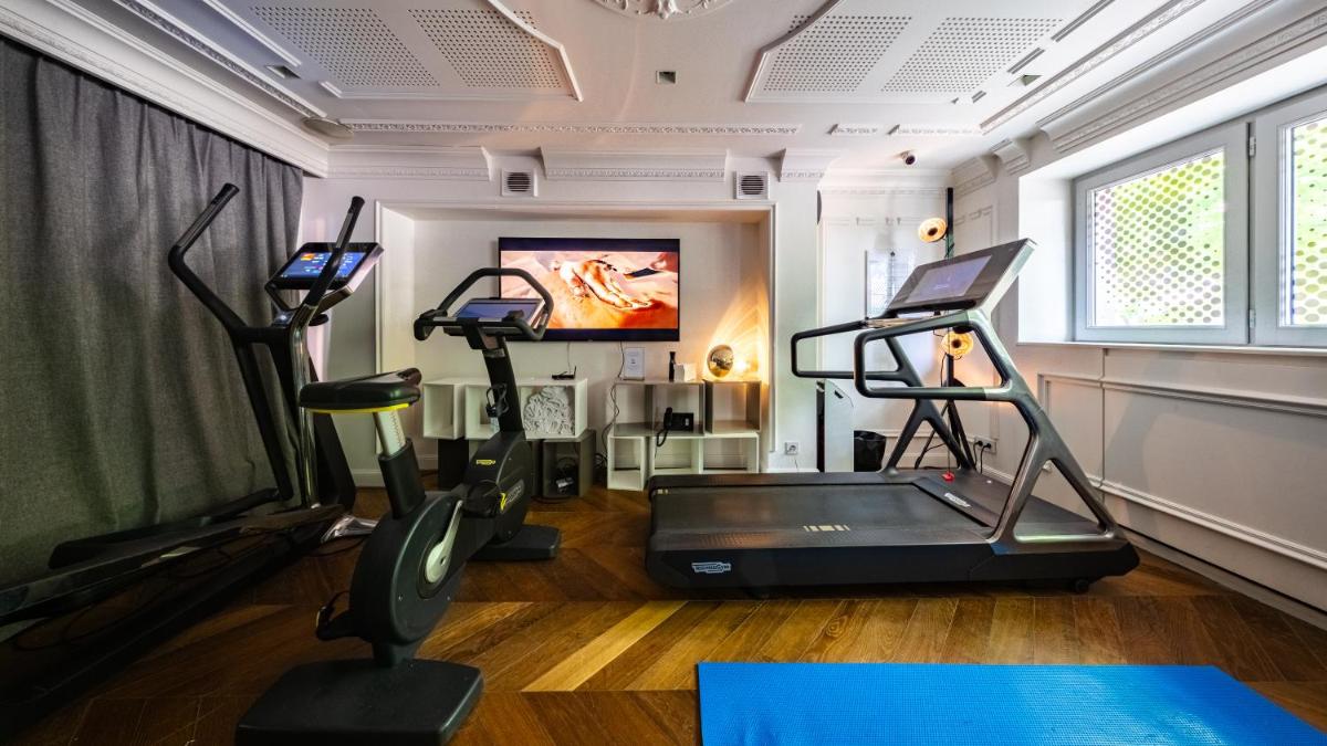une salle de sport avec deux tapis de course et un tapis de course dans l'établissement Vertigo Hotel, By Marriott, a Member of Design Hotels, à Dijon