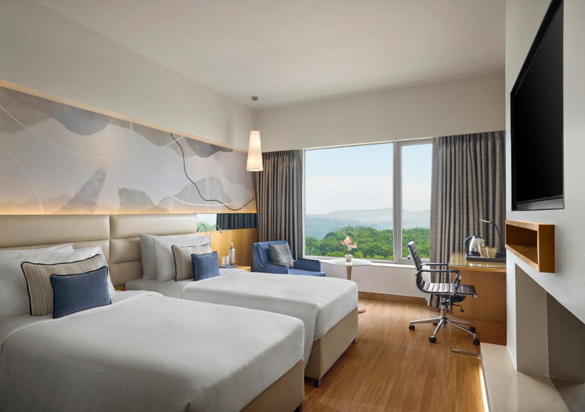 a hotel room with two beds and a window at The Fern Mumbai, Goregaon, Series by Marriott in Mumbai a hotel room with two beds and a window at The Fern Mumbai, Goregaon, Series by Marriott in Mumbai