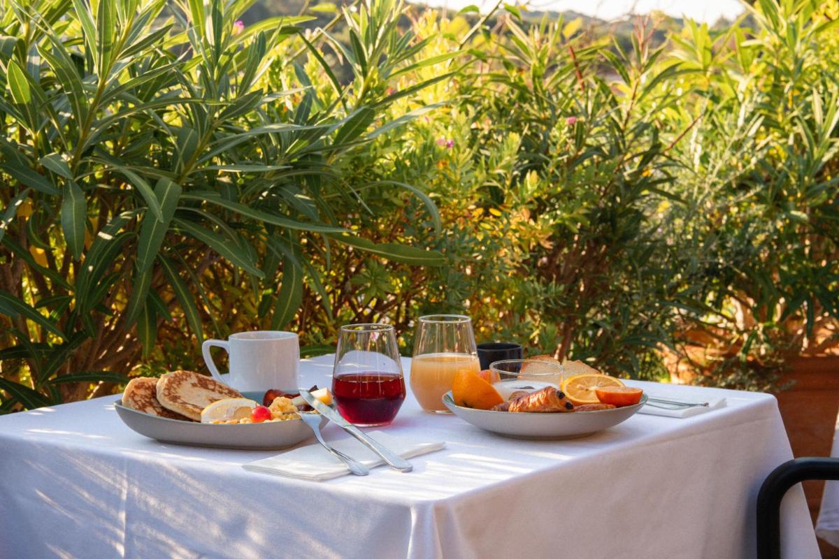 une table avec une assiette de nourriture et des verres de vin dans l'établissement Hôtel Helios & SPA - Ile des Embiez, à Six-Fours-les-Plages
