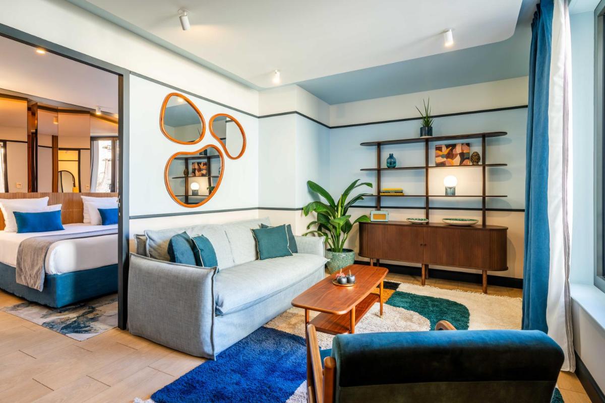 un salon avec un lit et un canapé dans l'établissement Quinzerie hôtel, à Paris