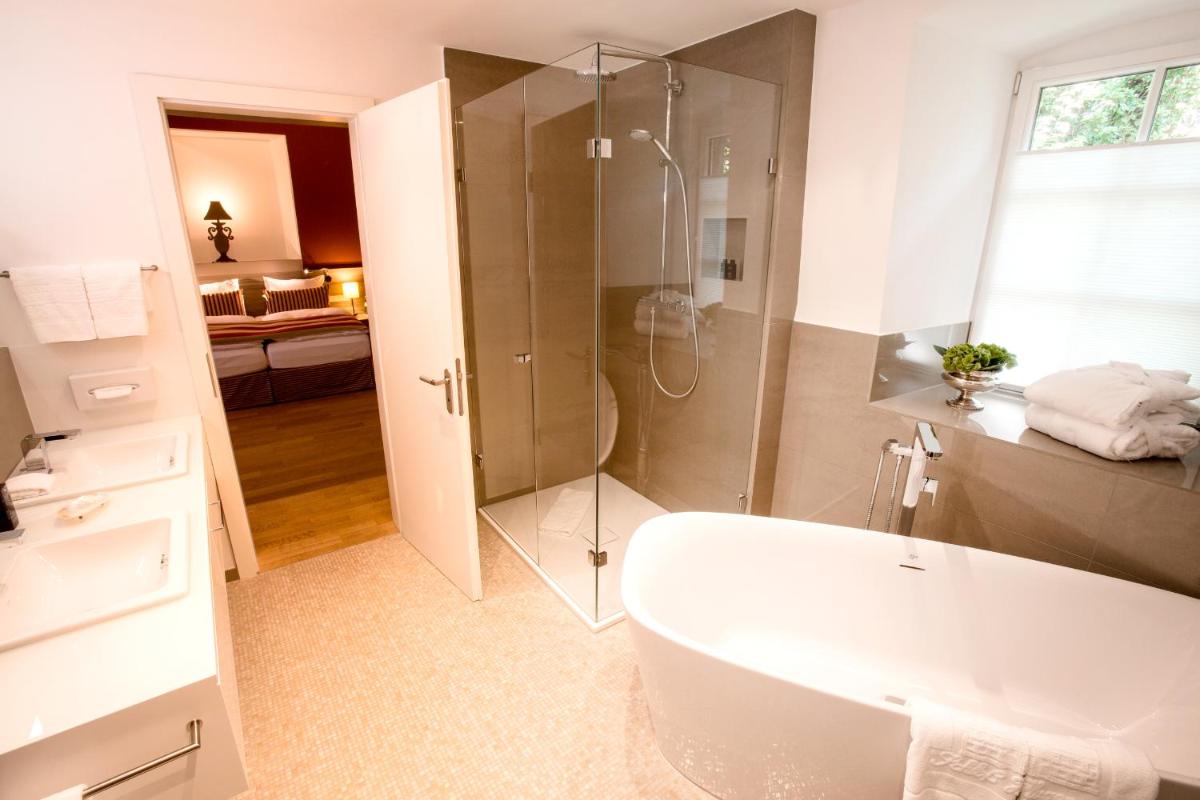 ein Badezimmer mit Dusche und Badewanne in der Unterkunft Schlosshotel Hugenpoet in Essen