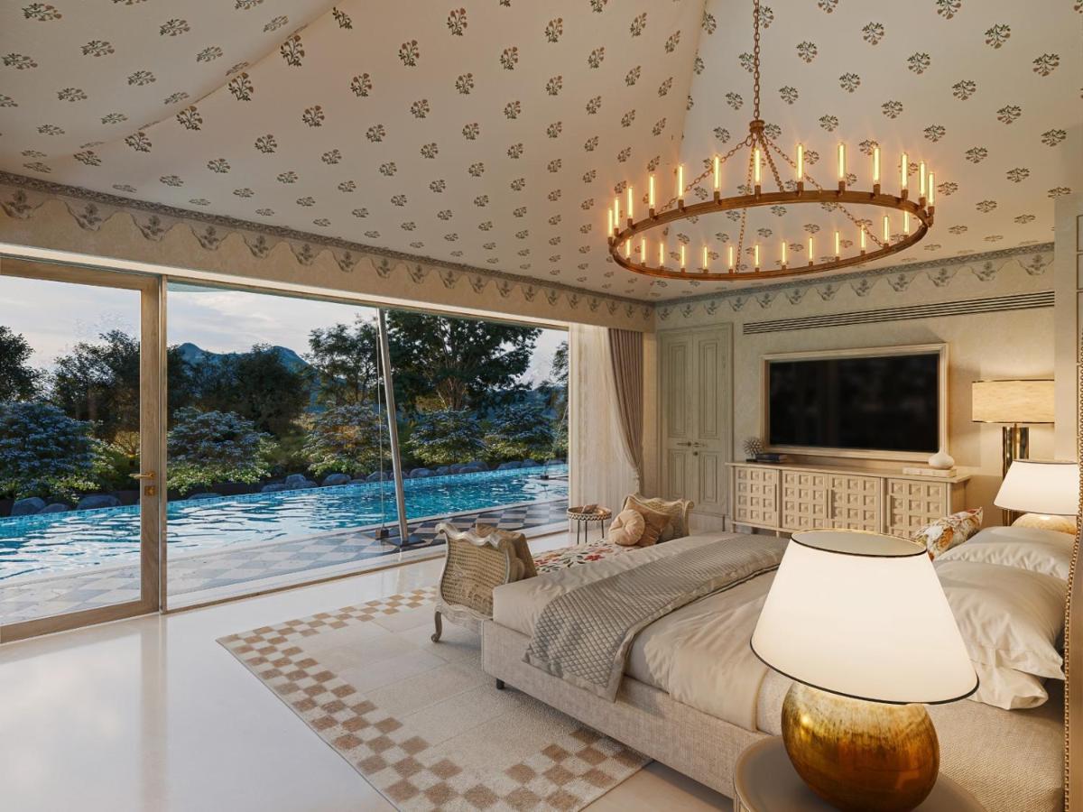 a bedroom with a large bed and a large window at Taj Aravali Resort & Spa Udaipur in Udaipur