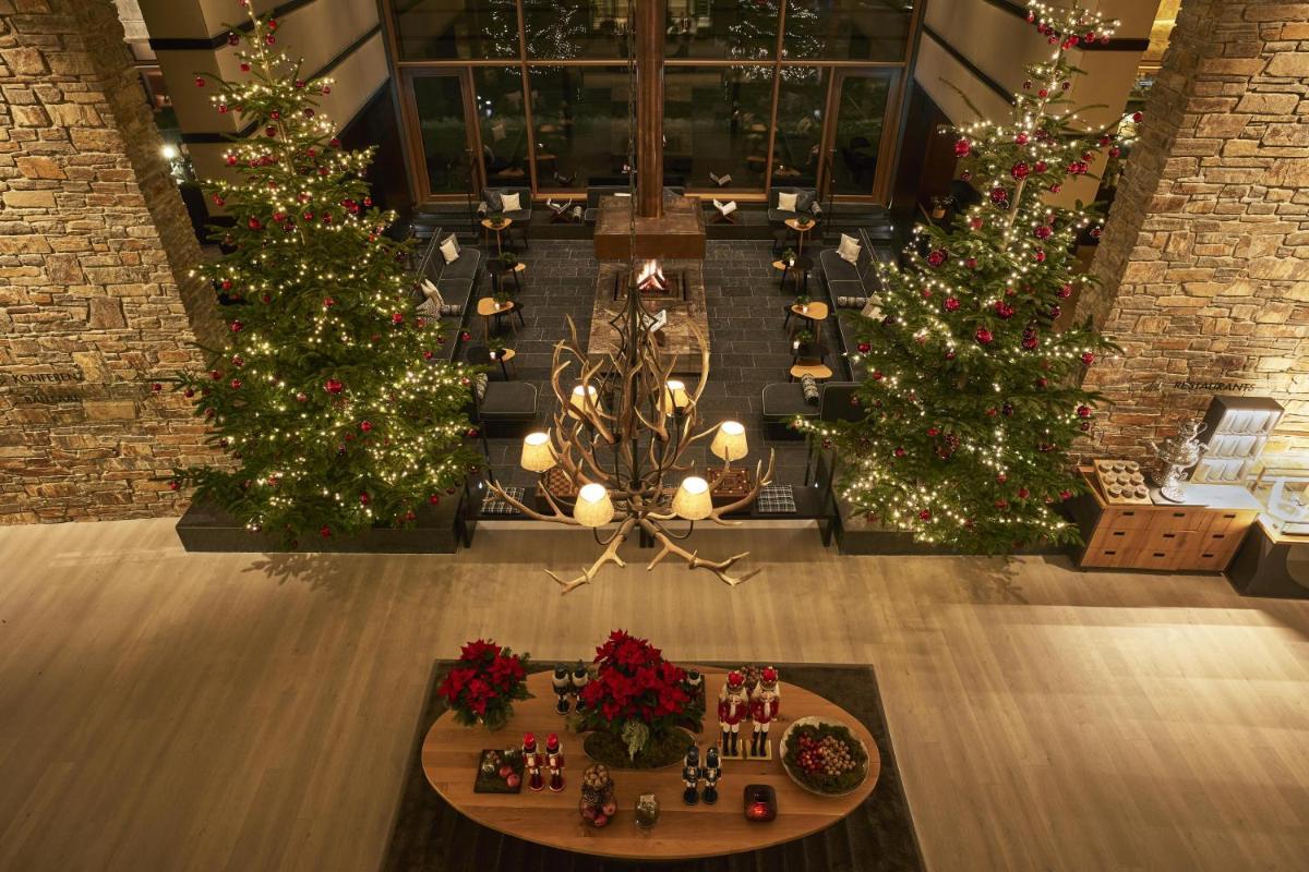 ein Zimmer mit drei Weihnachtsbäumen und Weihnachtsdekorationen in der Unterkunft Kempinski Hotel Berchtesgaden in Berchtesgaden