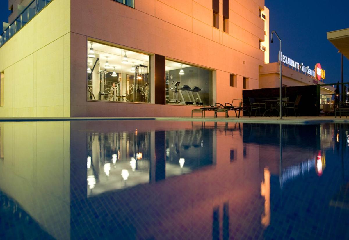 Una piscina frente a un edificio por la noche. en Executive Sport, en Totana