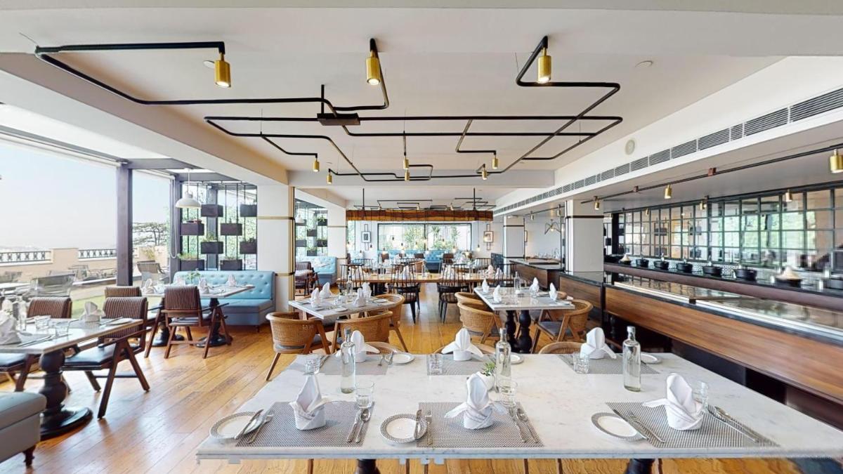 a restaurant with tables and chairs in a room at Radisson Hotel Shimla in Shimla