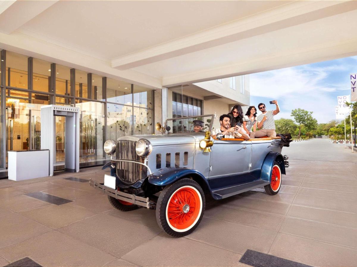 a group of people riding in an old car at Novotel Jaipur Convention Centre in Jaipur