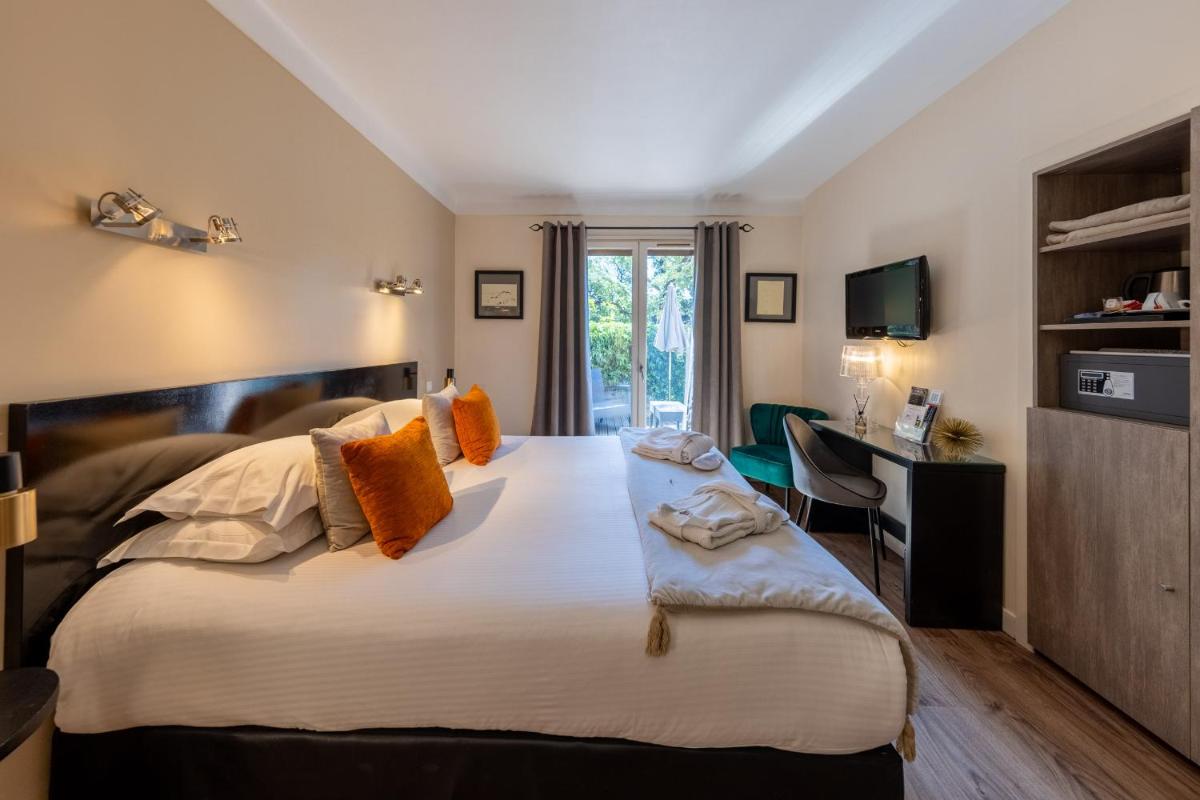 une chambre avec un grand lit et un bureau dans l'établissement Hôtel & Spa Le Madeloc - Collioure Centre, à Collioure