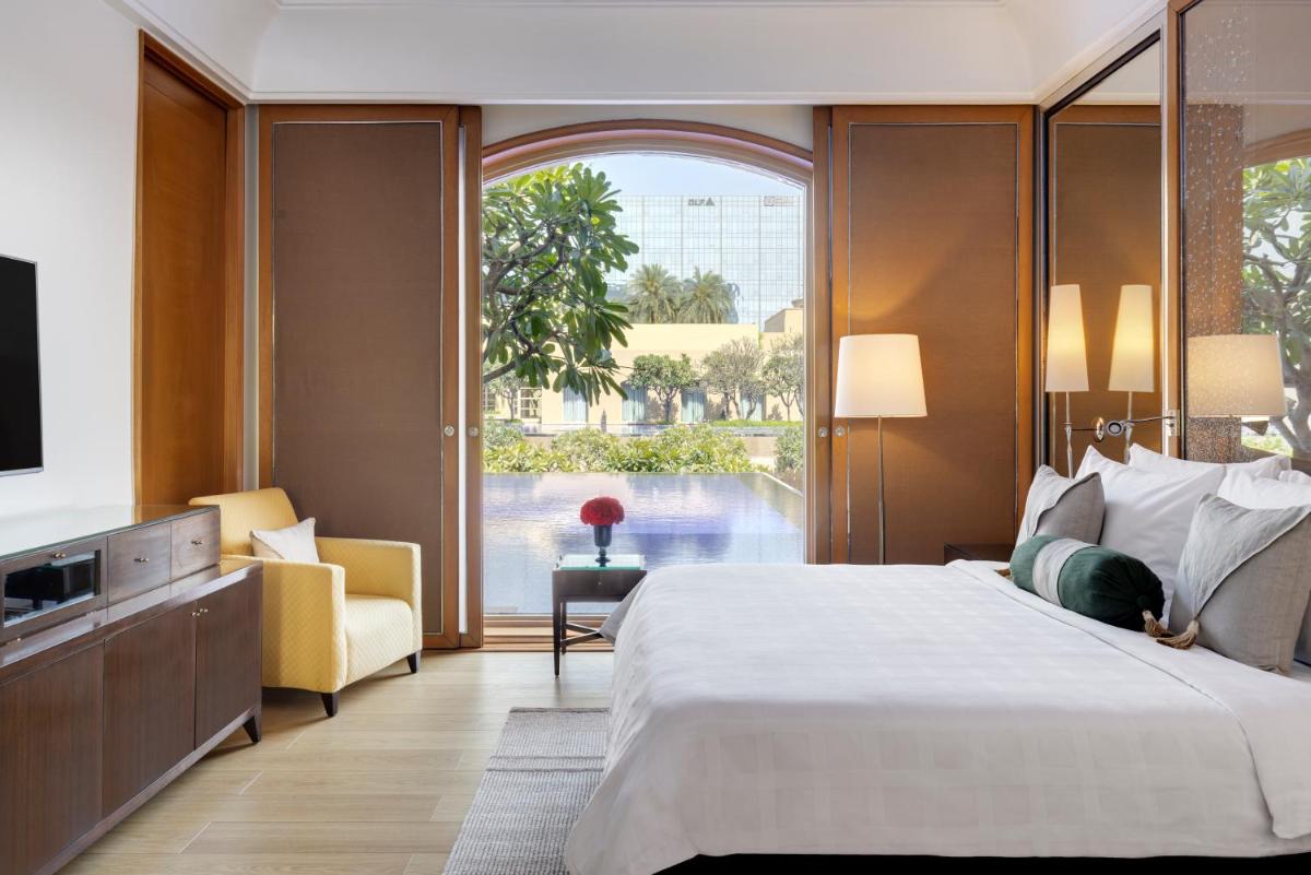 a bedroom with a large bed and a large window at Trident Gurgaon in Gurgaon