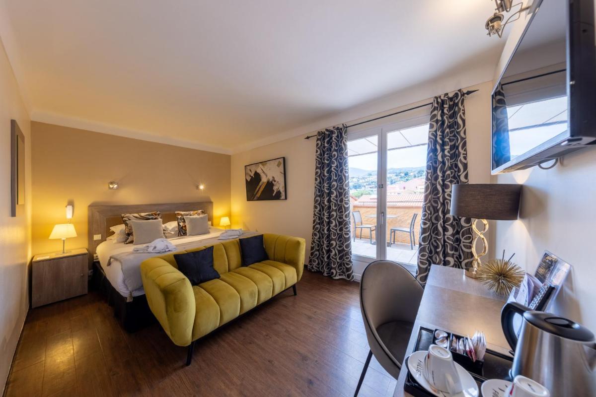 une chambre d'hôtel avec un lit et un canapé jaune dans l'établissement Hôtel & Spa Le Madeloc - Collioure Centre, à Collioure 126 autres photos