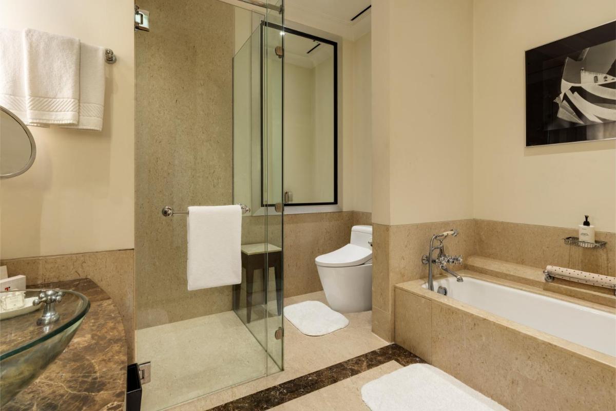 a bathroom with a tub and a toilet and a sink at Trident Gurgaon in Gurgaon