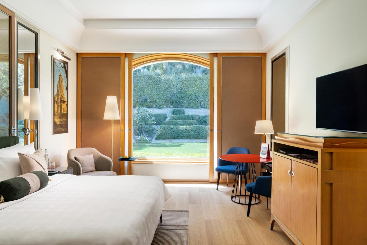 a hotel room with a bed and a large window at Trident Gurgaon in Gurgaon