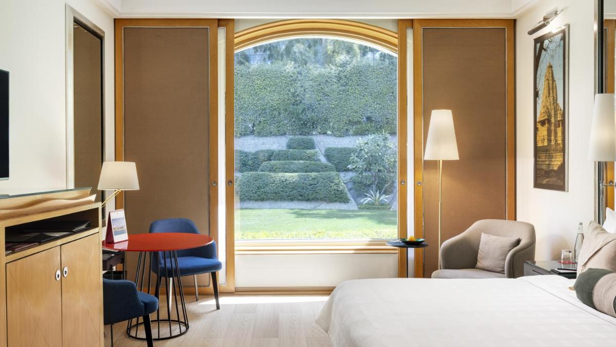 a hotel room with a bed and a window at Trident Gurgaon in Gurgaon