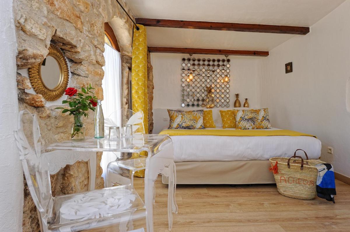 une chambre avec un lit et une table en verre dans l'établissement Lodge de Charme A Cheda, à Bonifacio