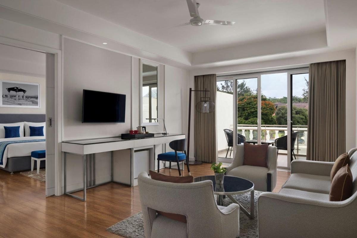 a living room with a desk and a bedroom at Amanora The Fern Pune, Series by Marriott in Pune