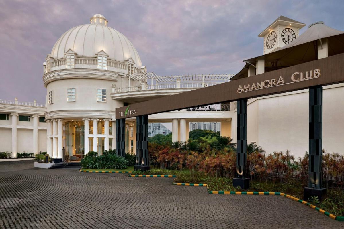 a white building with a clock tower on top of it at Amanora The Fern Pune, Series by Marriott in Pune