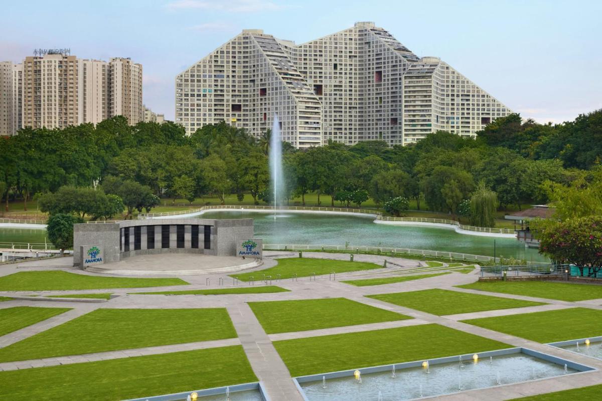 a fountain in a park with tall buildings in the background at Amanora The Fern Pune, Series by Marriott in Pune