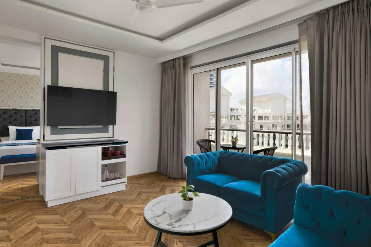 a living room with a blue couch and a tv at Amanora The Fern Pune, Series by Marriott in Pune