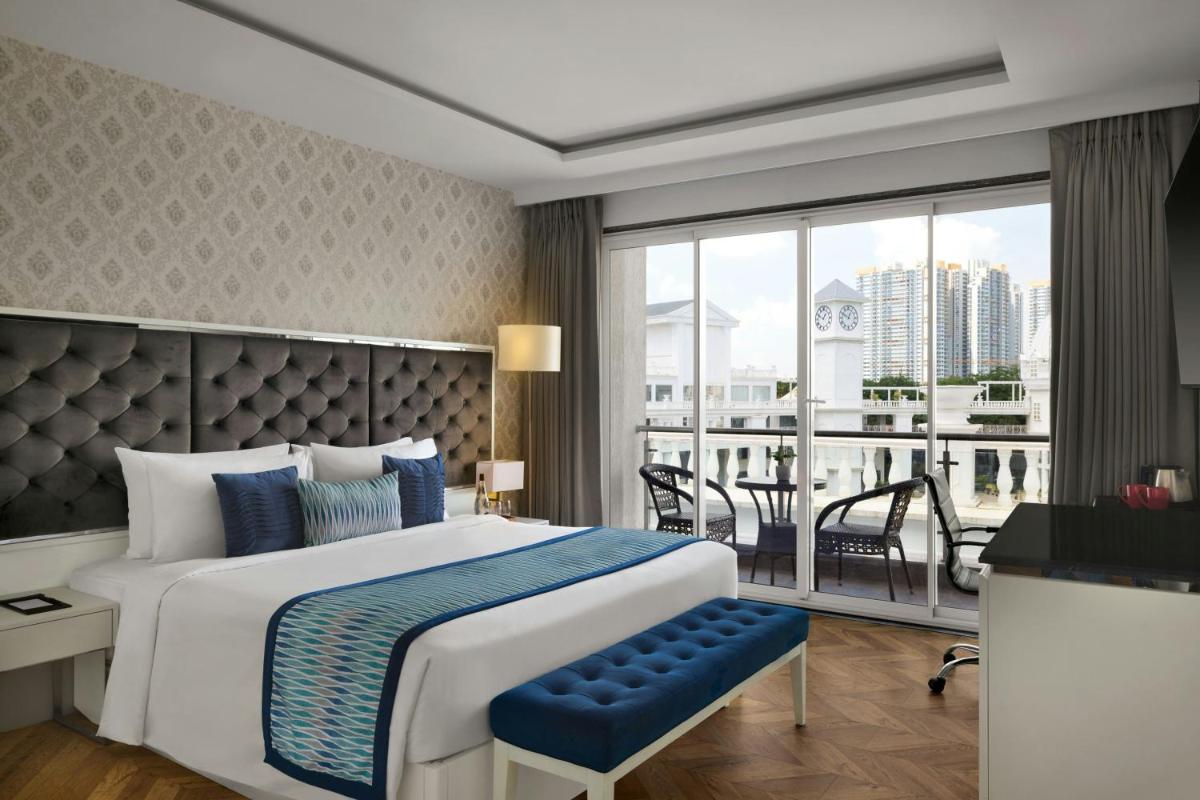 a bedroom with a large bed and a balcony at Amanora The Fern Pune, Series by Marriott in Pune