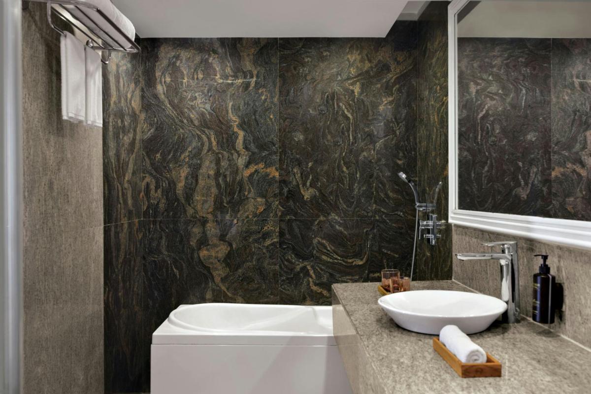 a bathroom with a sink and a toilet and a mirror at Amanora The Fern Pune, Series by Marriott in Pune