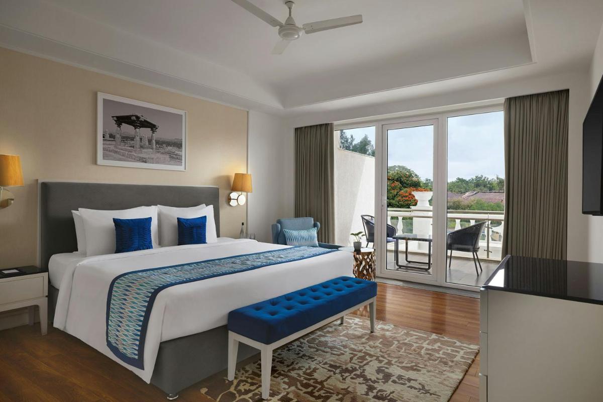 a bedroom with a large bed and a balcony at Amanora The Fern Pune, Series by Marriott in Pune