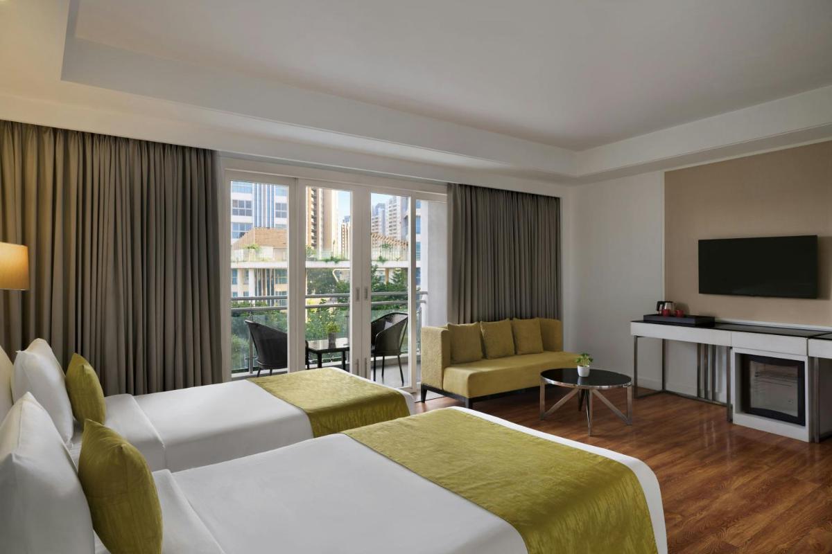 a hotel room with two beds and a television at Amanora The Fern Pune, Series by Marriott in Pune