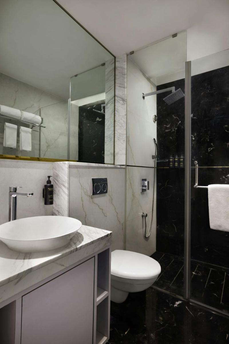 a bathroom with a toilet and a sink and a shower at Amanora The Fern Pune, Series by Marriott in Pune
