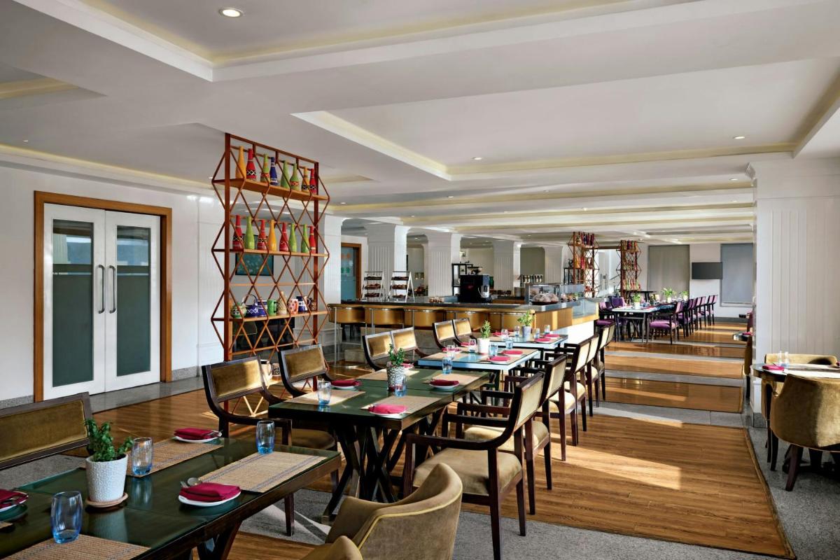 a restaurant with tables and chairs and a bar at Amanora The Fern Pune, Series by Marriott in Pune