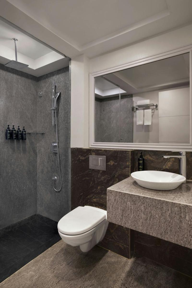 a bathroom with a toilet and a sink and a shower at Amanora The Fern Pune, Series by Marriott in Pune