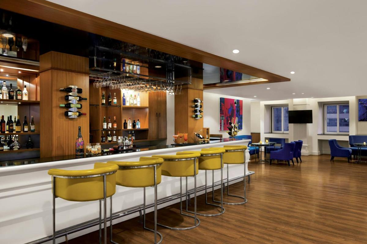 a bar with yellow bar stools in a restaurant at Amanora The Fern Pune, Series by Marriott in Pune