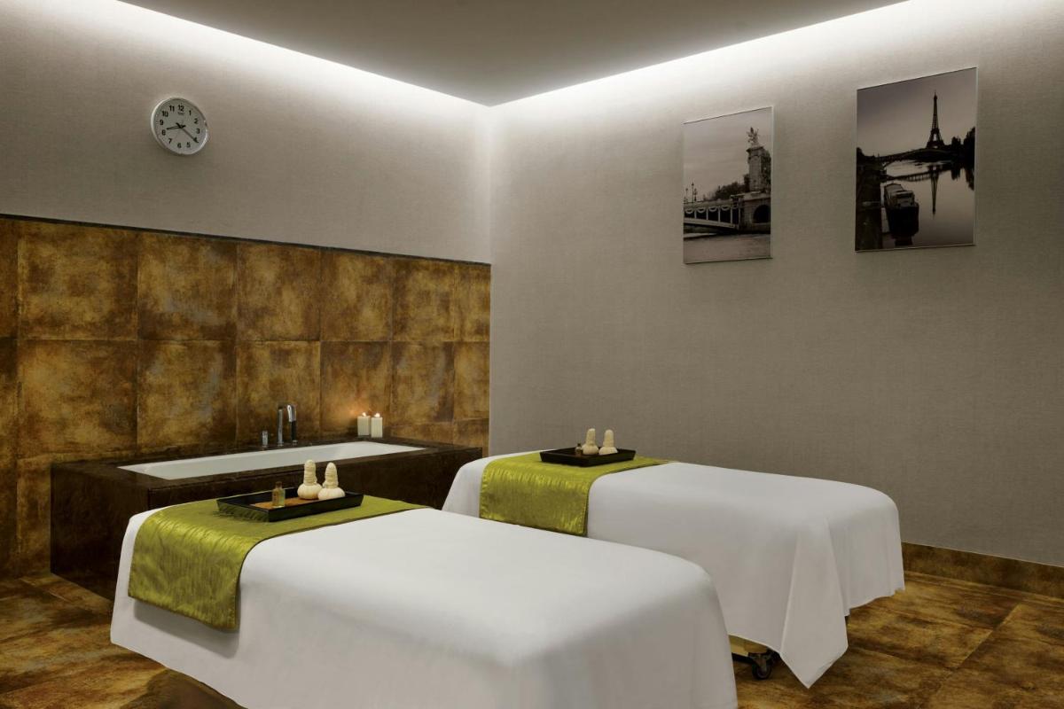 a room with two beds and a sink at Amanora The Fern Pune, Series by Marriott in Pune
