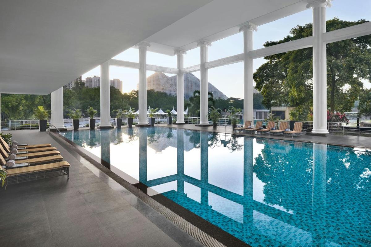 a swimming pool with chairs and a building at Amanora The Fern Pune, Series by Marriott in Pune