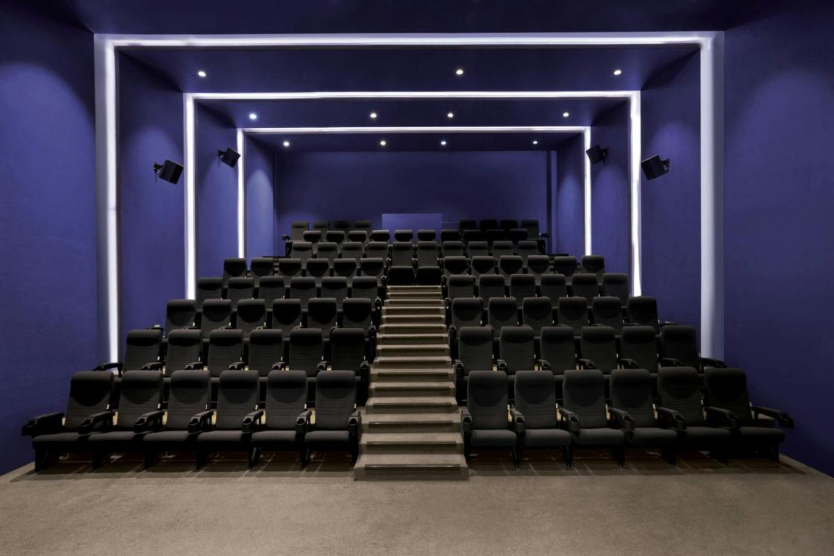 an empty theatre with stairs in a blue room at Amanora The Fern Pune, Series by Marriott in Pune