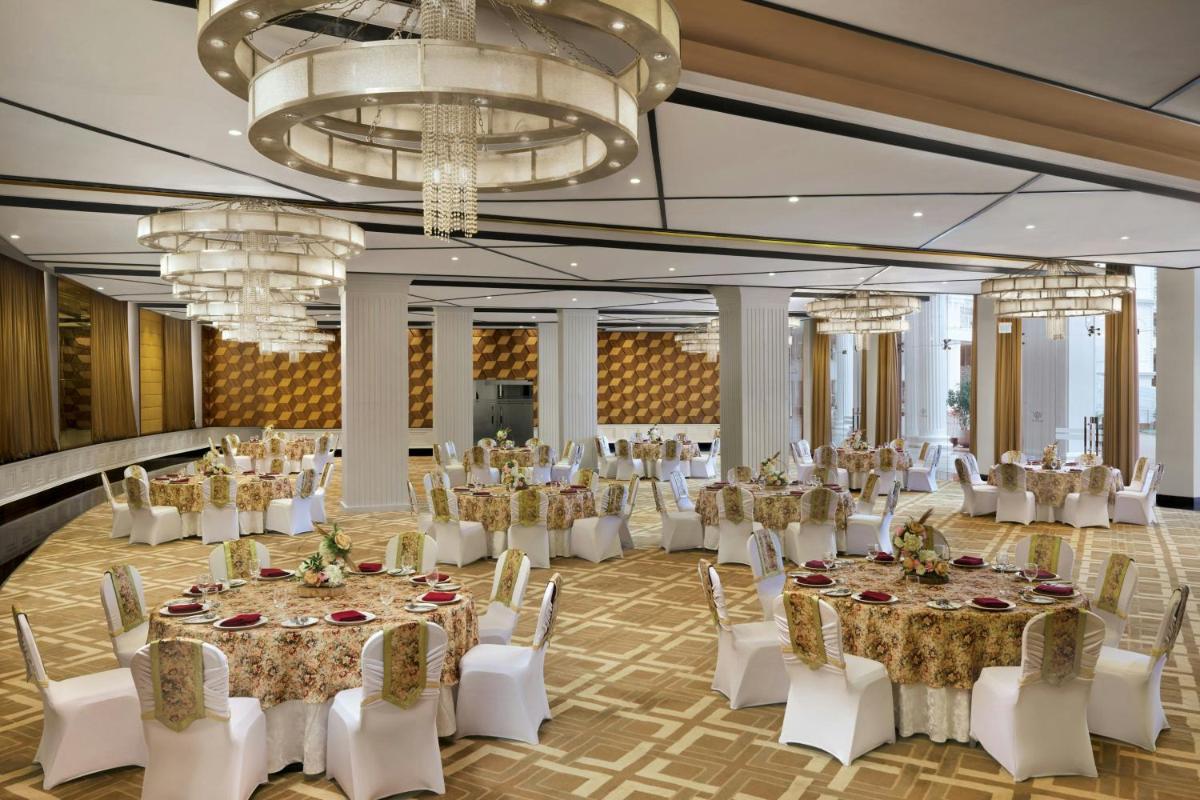 a banquet hall with tables and chairs and chandeliers at Amanora The Fern Pune, Series by Marriott in Pune +17 photos