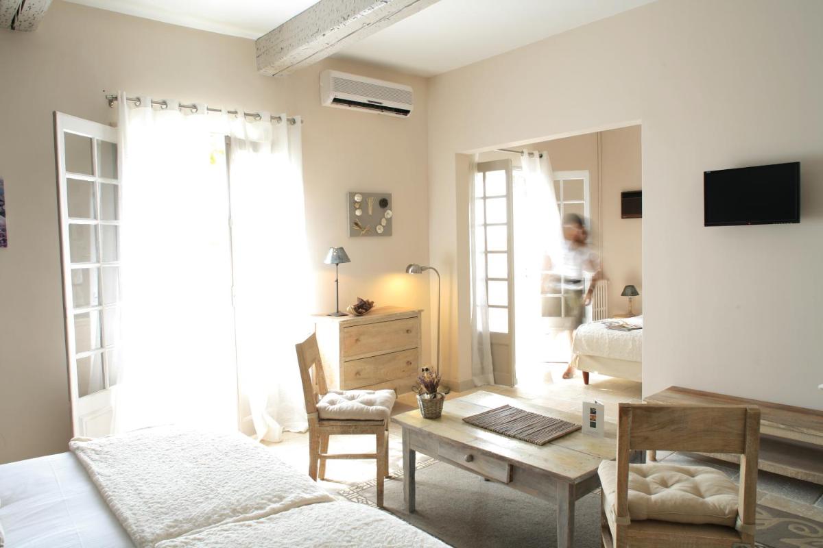 une chambre avec deux lits, une table et un bureau dans l'établissement La Regalido, à Fontvieille