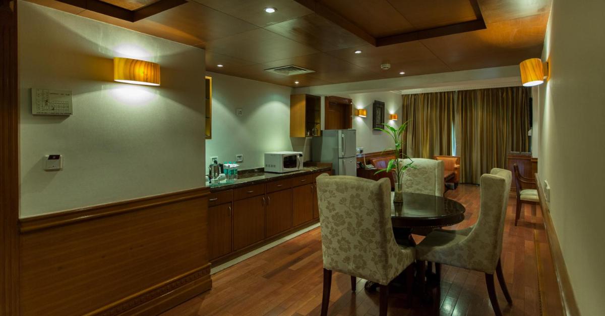 a kitchen and dining room with a table and chairs at The Chancery Pavilion in Bengaluru