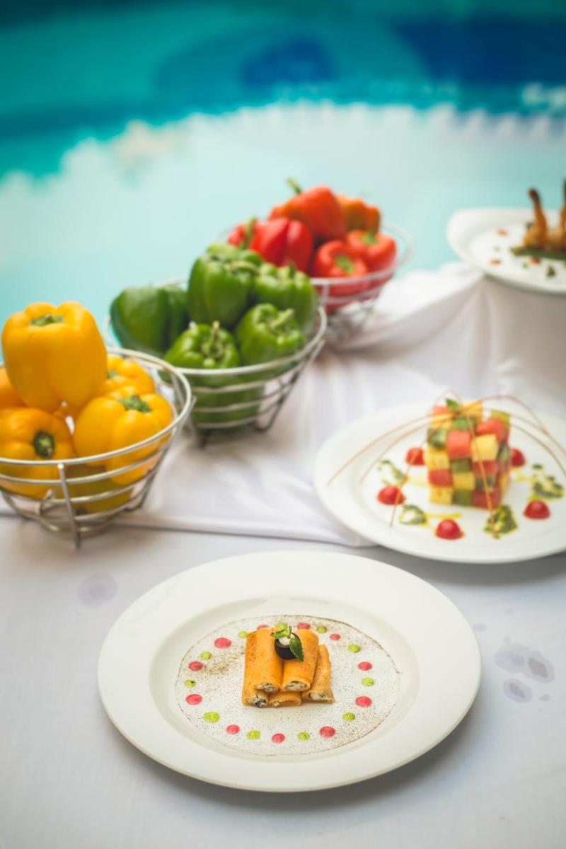 a table with plates of food and bowls of fruit at The Chancery Pavilion in Bengaluru