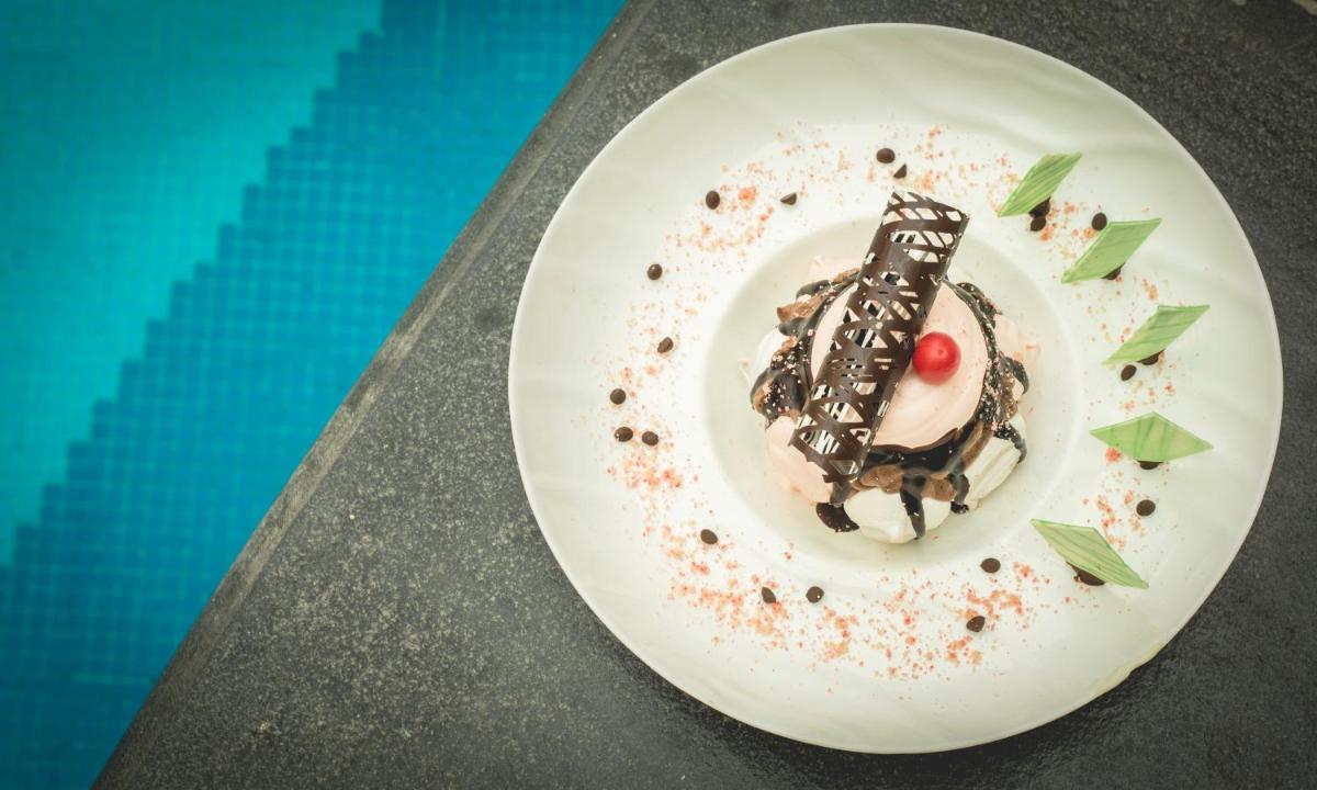 a piece of cake on a plate next to a pool at The Chancery Pavilion in Bengaluru