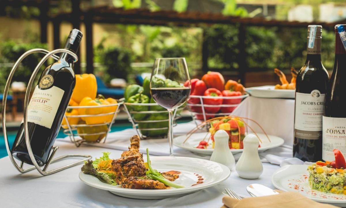 a table with plates of food and bottles of wine at The Chancery Pavilion in Bengaluru