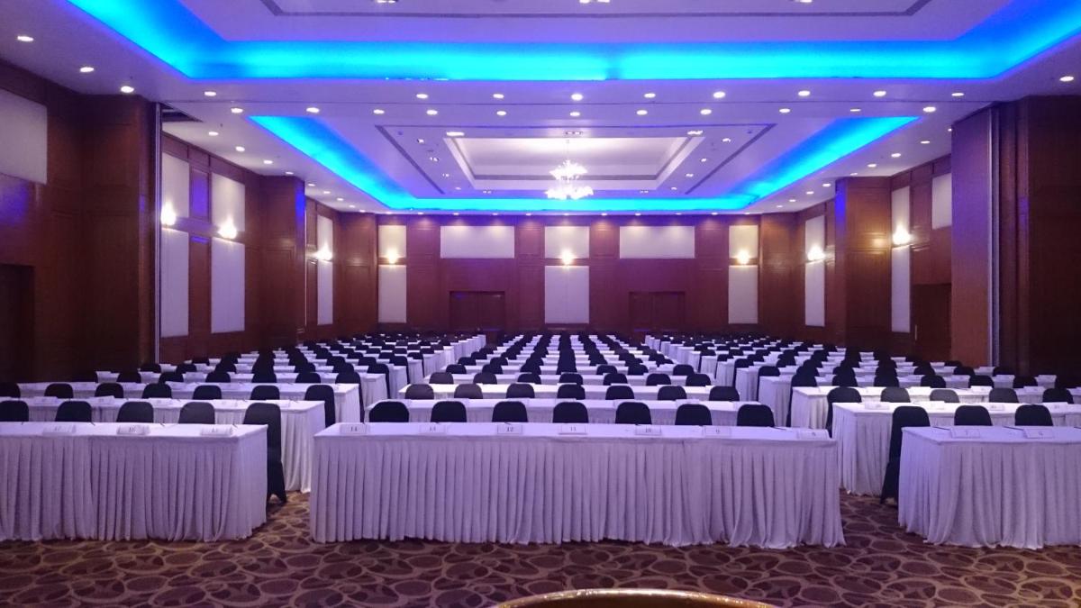 a banquet hall with white tables and chairs and blue lighting at The Chancery Pavilion in Bengaluru