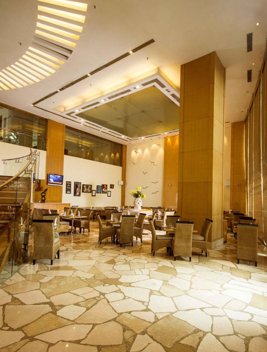 a lobby with chairs and tables in a building at The Chancery Pavilion in Bengaluru