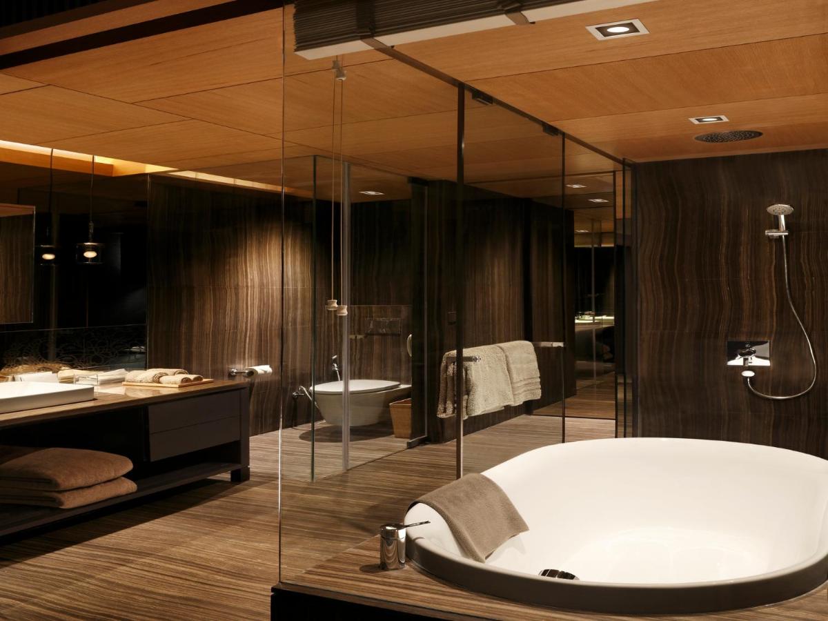 a bathroom with a tub and a shower and a sink at Roseate House New Delhi in New Delhi a bathroom with a tub and a shower and a sink at Roseate House New Delhi in New Delhi