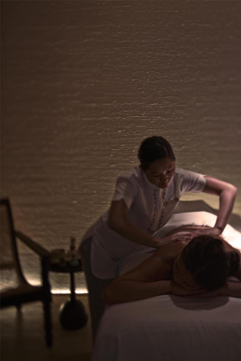 a woman is sitting on top of a bed at Park Hyatt Chennai in Chennai