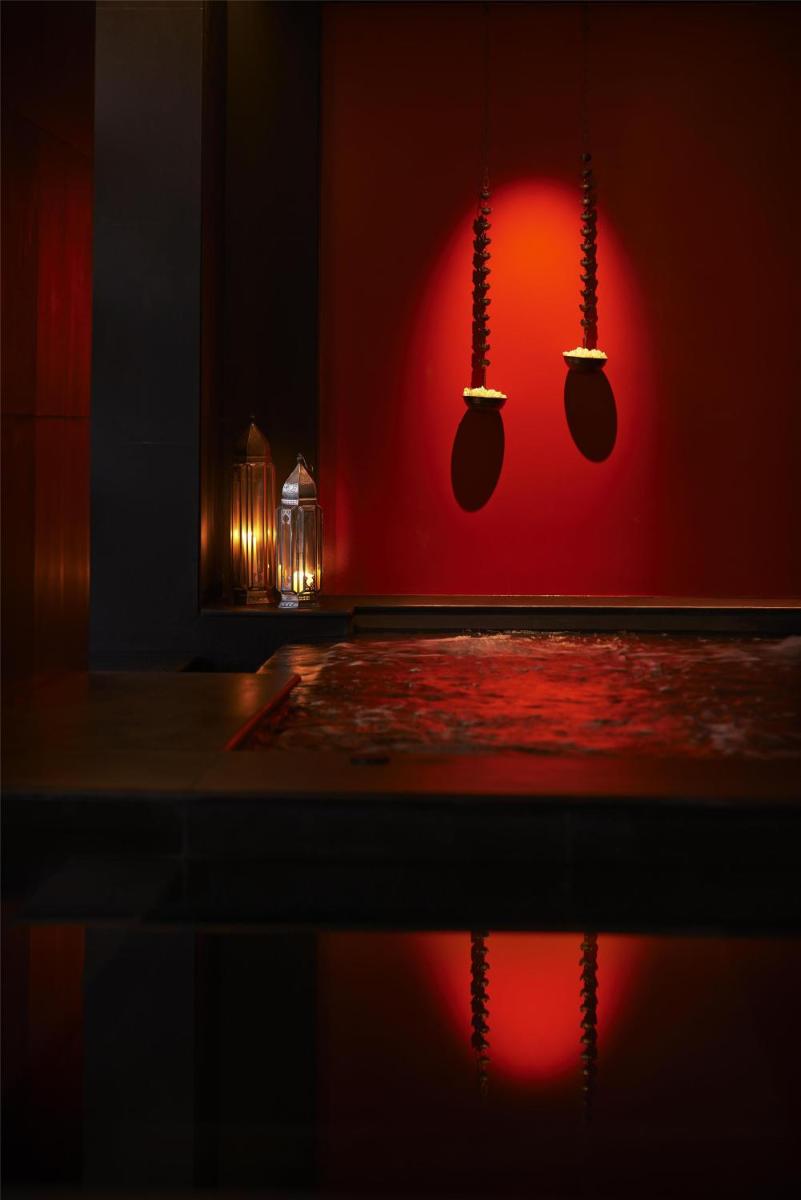a bathroom with a red wall with mitts on it at Park Hyatt Chennai in Chennai