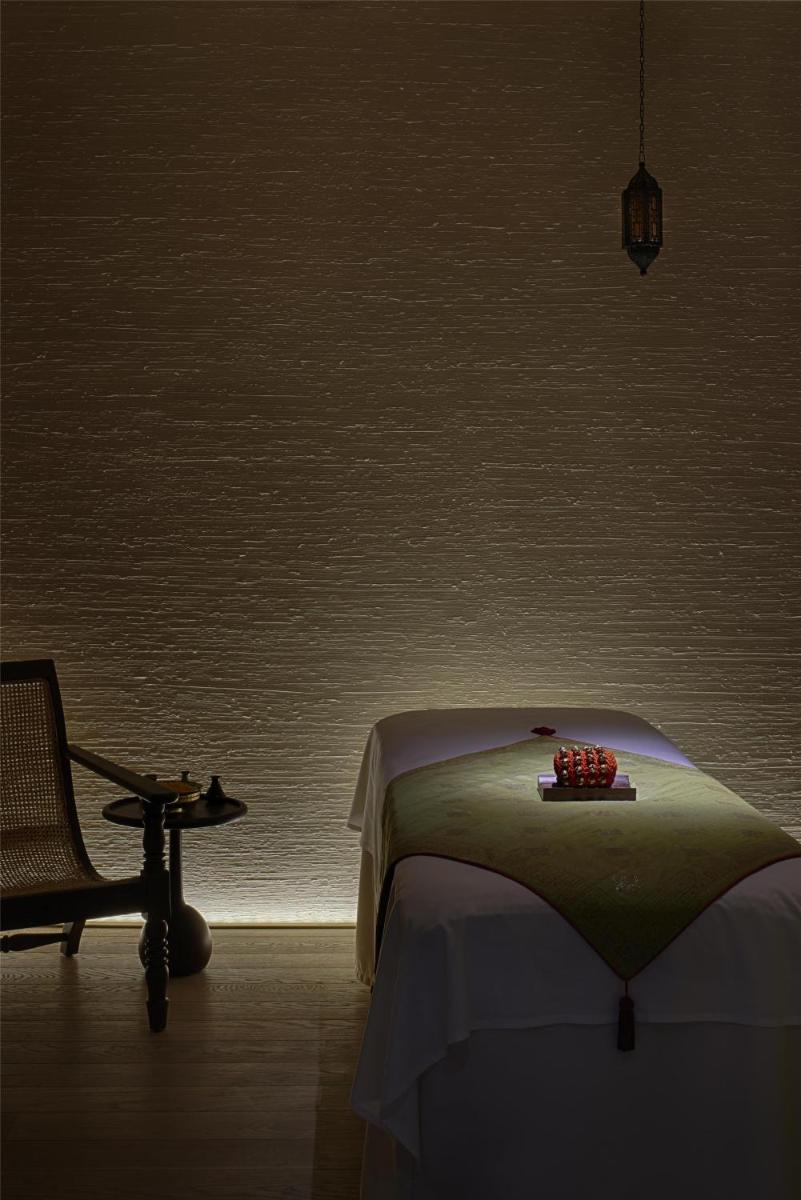 a bedroom with a bed and a chair and a table at Park Hyatt Chennai in Chennai