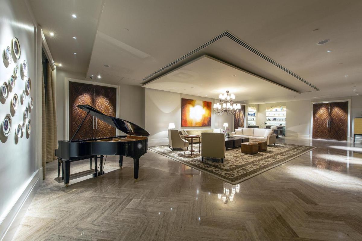 a living room with a piano and a dining room at Park Hyatt Chennai in Chennai