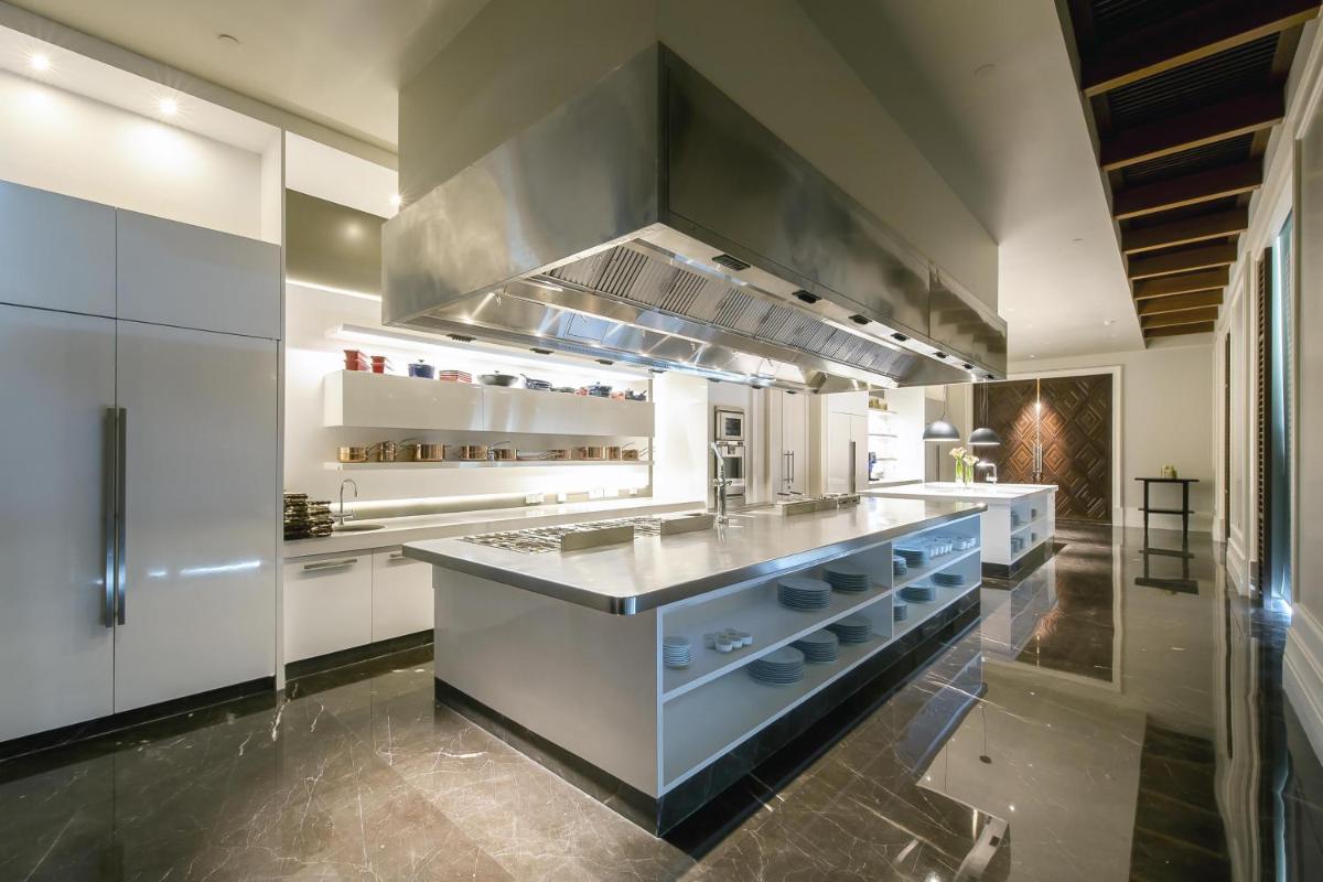 a large kitchen with white cabinets and a large island at Park Hyatt Chennai in Chennai